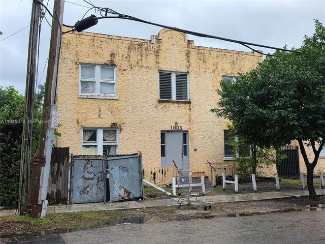 a front view of a house with a tree