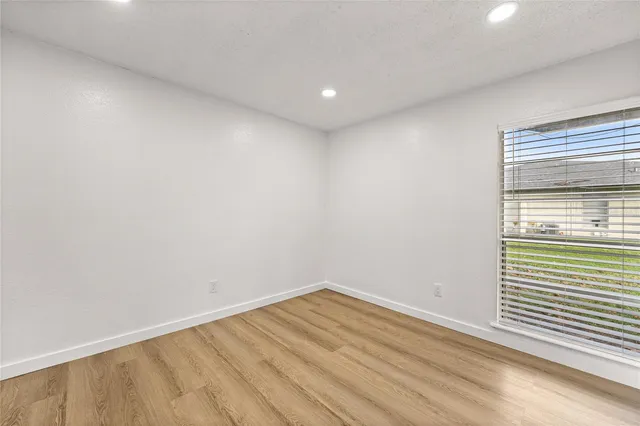 a view of empty room with wooden floor