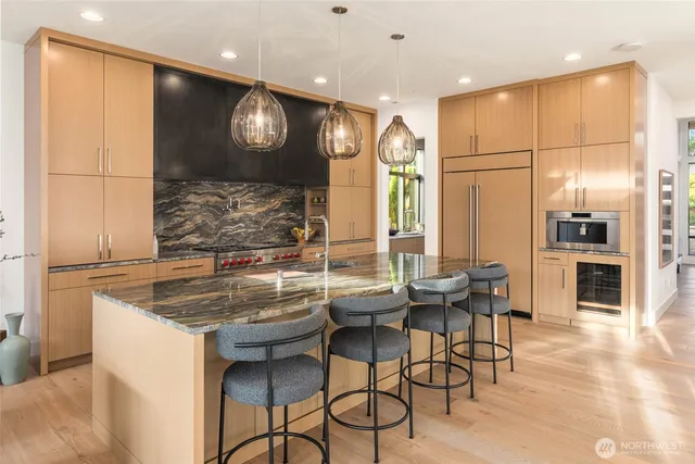 a large kitchen with stainless steel appliances a stove and a large window
