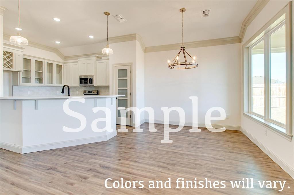 7648 Mountain View Road Abilene, TX 79602 - Photo 4 of 21 a kitchen with kitchen island granite countertop a stove a sink a dining table and chairs with wooden floor