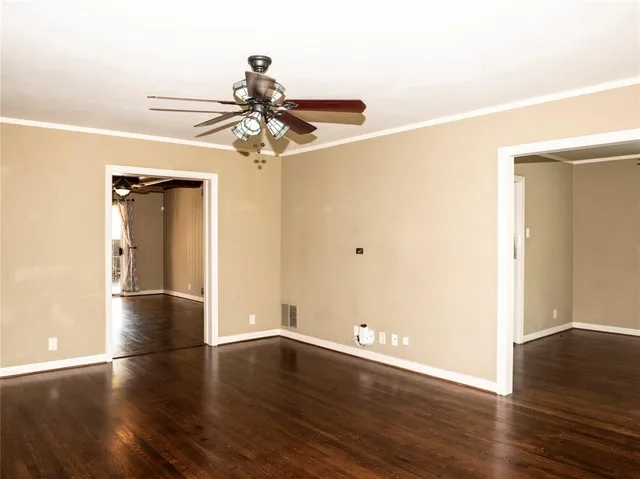 an empty room with wooden floor closet and windows