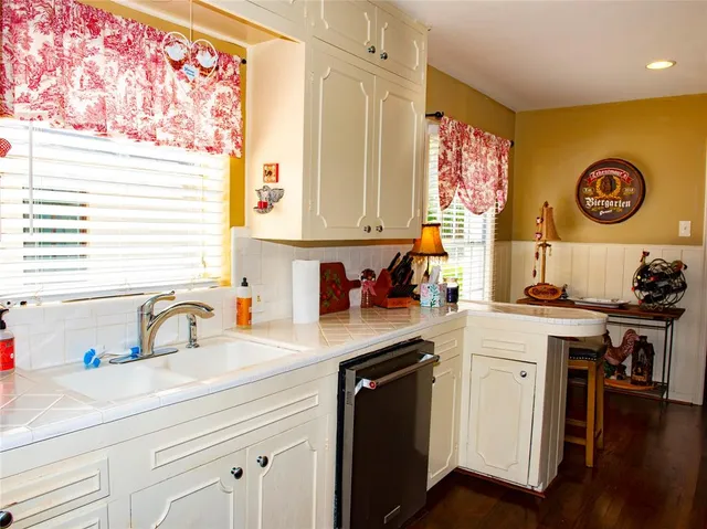 a kitchen with a sink cabinets and wooden floor