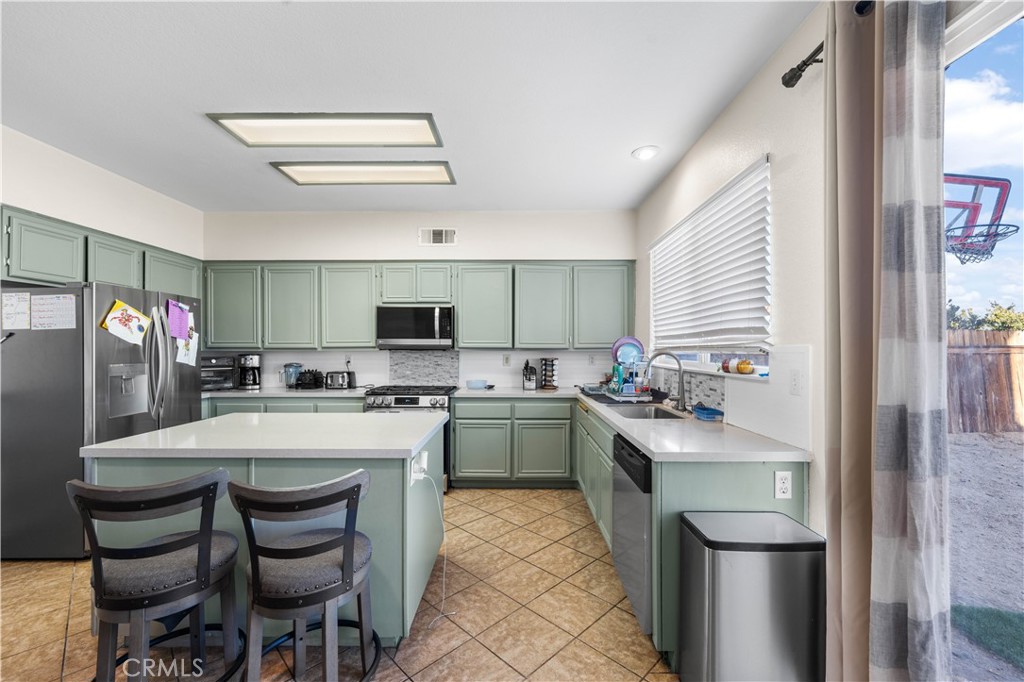 36624 Roosevelt Drive Palmdale, CA 93552 - Photo 8 of 12 a kitchen with a sink a stove and chairs