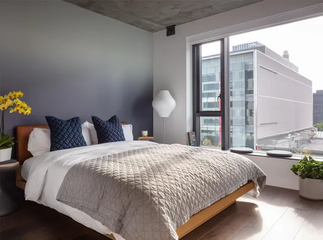 a bedroom with bed and a large window