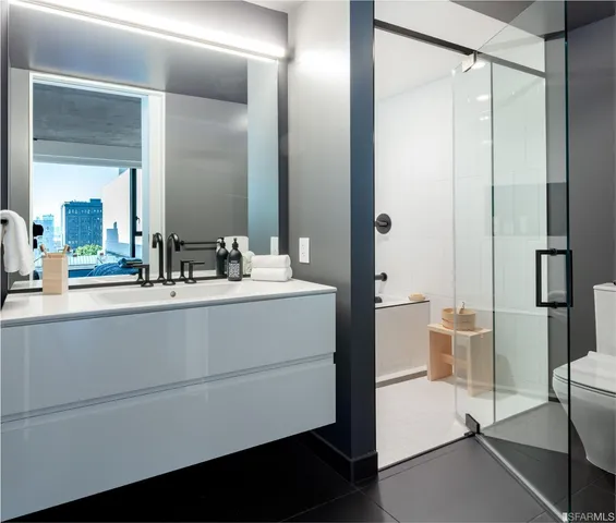 a bathroom with a double vanity sink toilet and shower