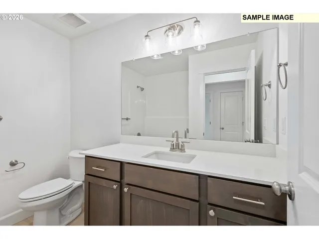 a bathroom with a sink vanity granite and toilet