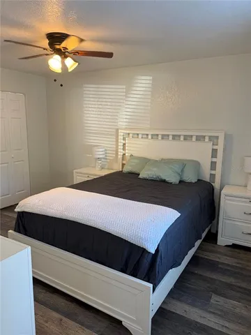 a bedroom with a bed and a large mirror next to a window