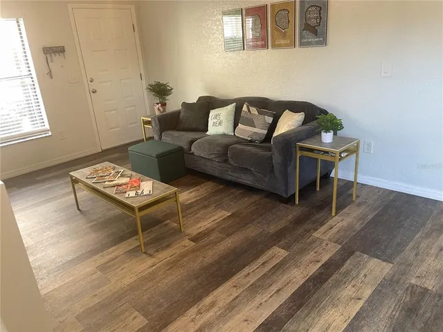a living room with furniture and a wooden floor