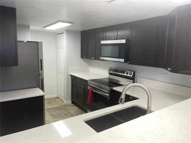 a kitchen with a refrigerator and a stove top oven