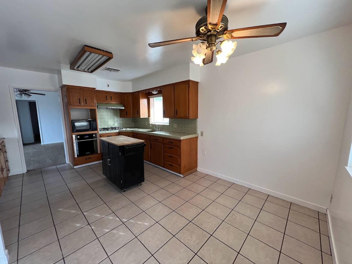 16109 East Manning Reedley, CA 93654 - Photo 5 of 30 a kitchen with stainless steel appliances granite countertop a sink and a refrigerator