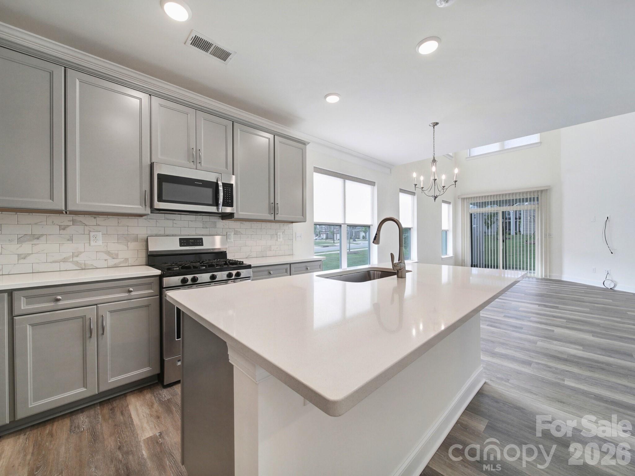4003 Rothwood Lane Harrisburg, NC 28075 - Photo 5 of 30 a large kitchen with kitchen island a sink a stove and cabinets