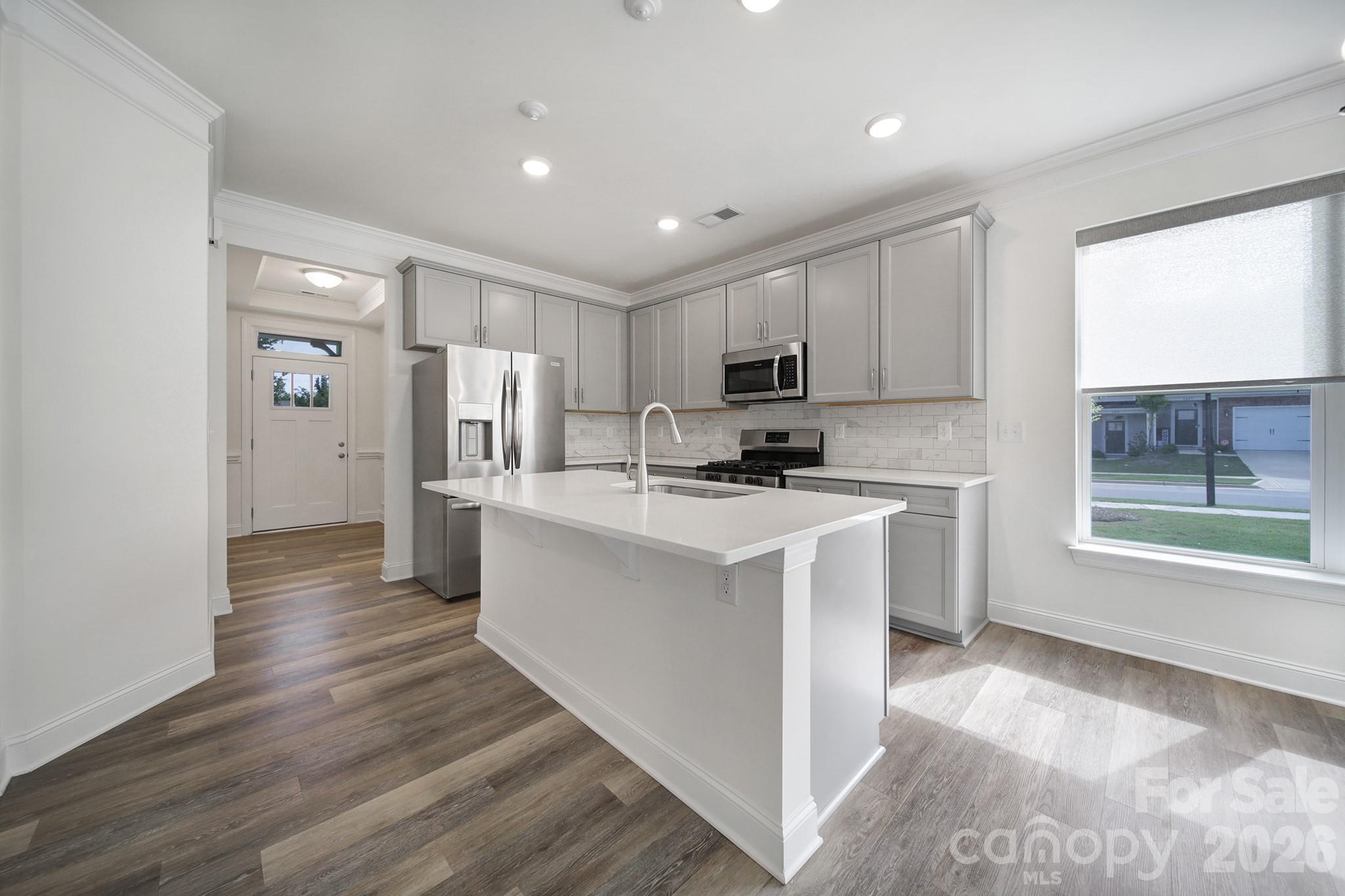 4003 Rothwood Lane Harrisburg, NC 28075 - Photo 6 of 30 a kitchen with cabinets and wooden floor