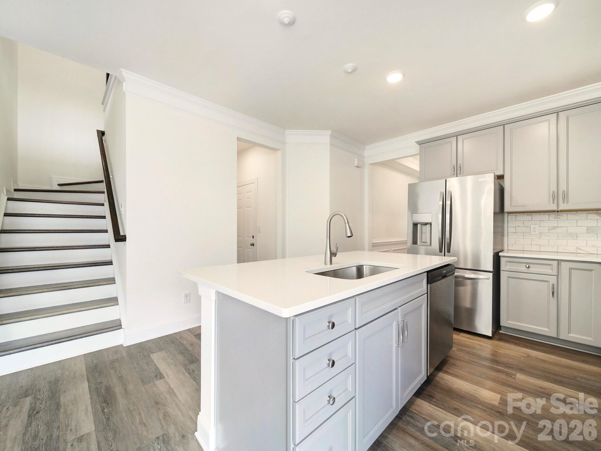 4003 Rothwood Lane Harrisburg, NC 28075 - Photo 7 of 30 a kitchen with a sink a refrigerator and cabinets