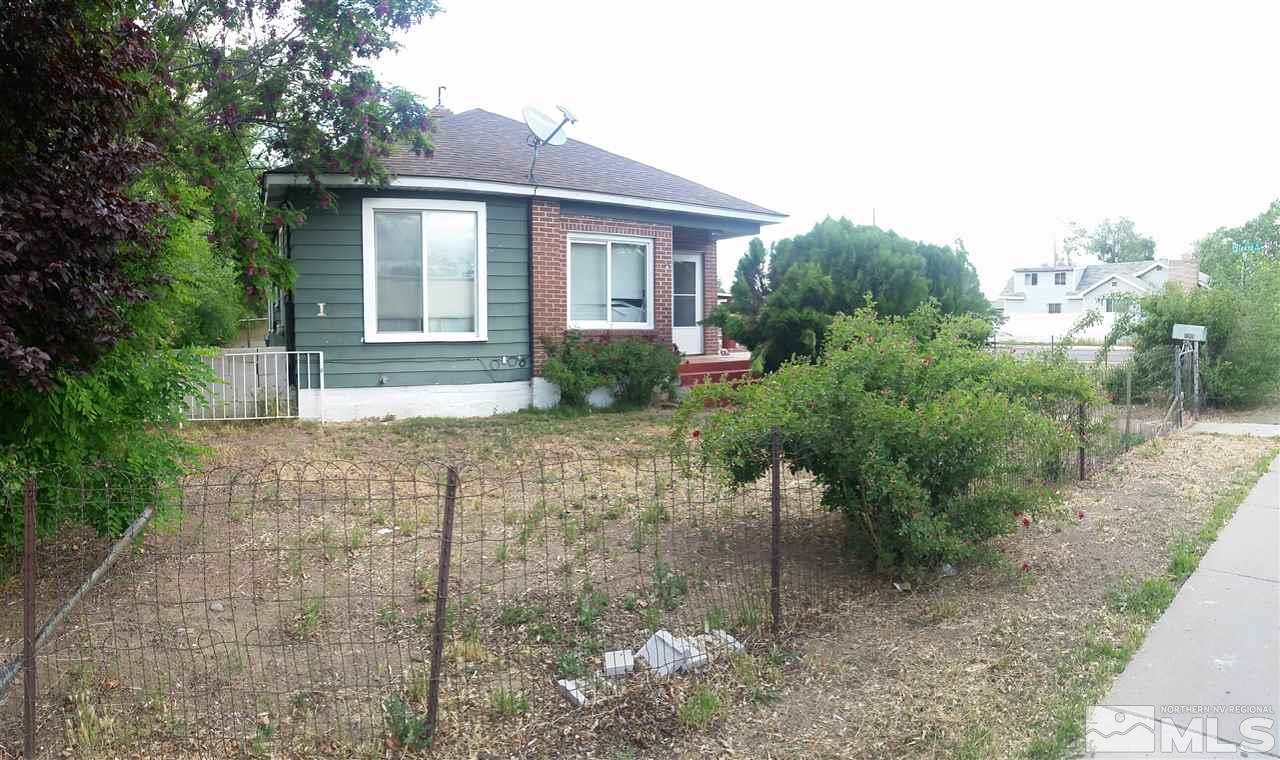 a front view of a house with a yard and potted plants
