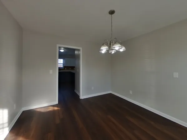a view of a room with wooden floor and chandelier