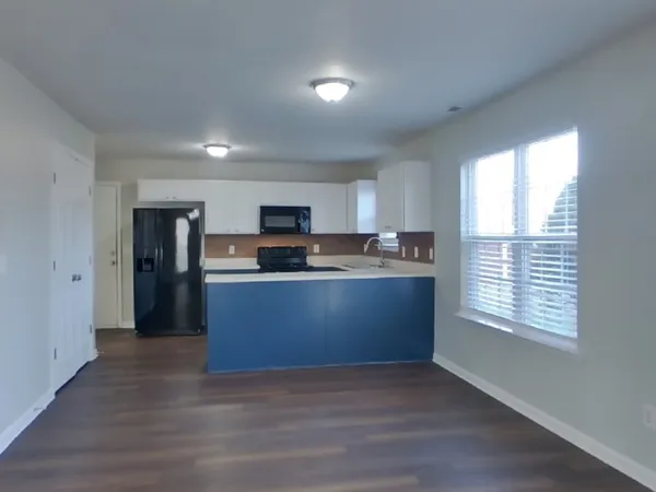 a kitchen with stainless steel appliances granite countertop a stove a refrigerator a sink a microwave and cabinets