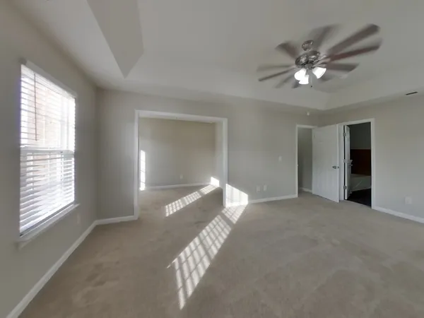 a view of a big room with windows and chandelier fan