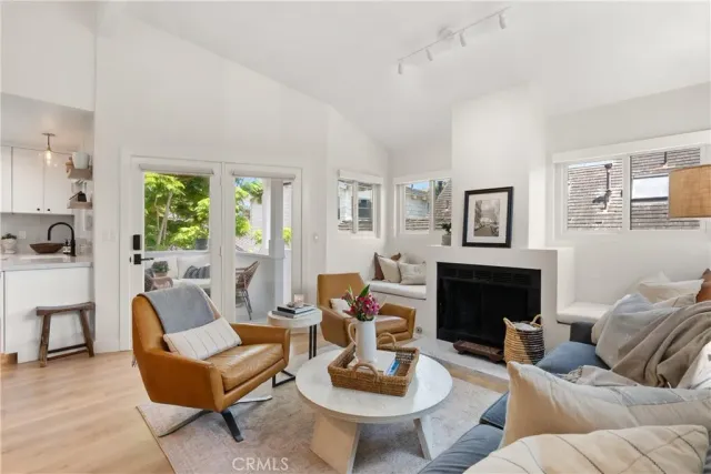 a living room with furniture a fireplace and a large window