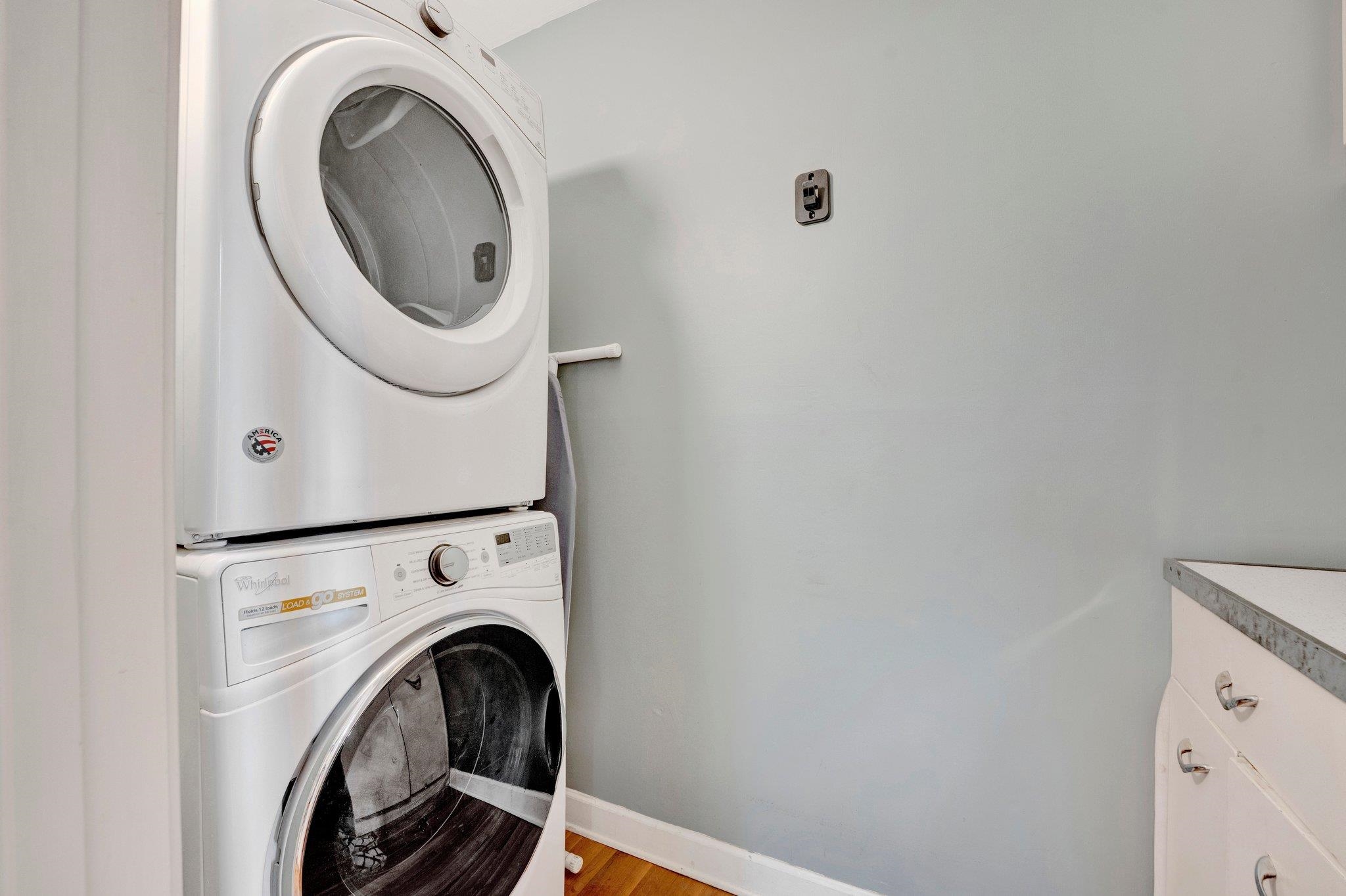 4500 East Dearing Road Memphis, TN 38117 - Photo 15 of 18 Laundry area featuring stacked washing maching and dryer, cabinets, and light hardwood / wood-style flooring