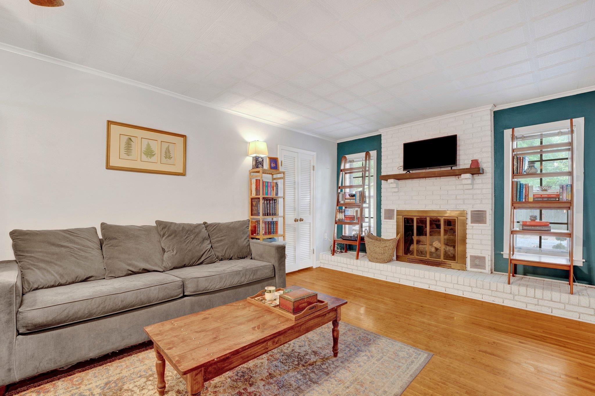 4500 East Dearing Road Memphis, TN 38117 - Photo 5 of 18 Living room with crown molding, a brick fireplace, and hardwood / wood-style flooring