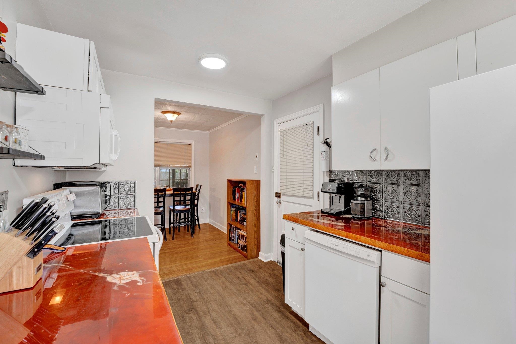 4500 East Dearing Road Memphis, TN 38117 - Photo 8 of 18 Kitchen featuring white appliances, backsplash, white cabinetry, and light hardwood / wood-style flooring