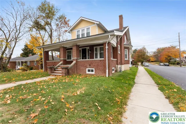 a front view of a house with a yard and fountain