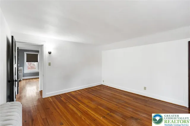 a view of a room with wooden floor and a hallway