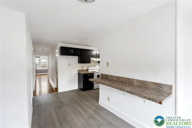 a kitchen with granite countertop a refrigerator and a stove top oven