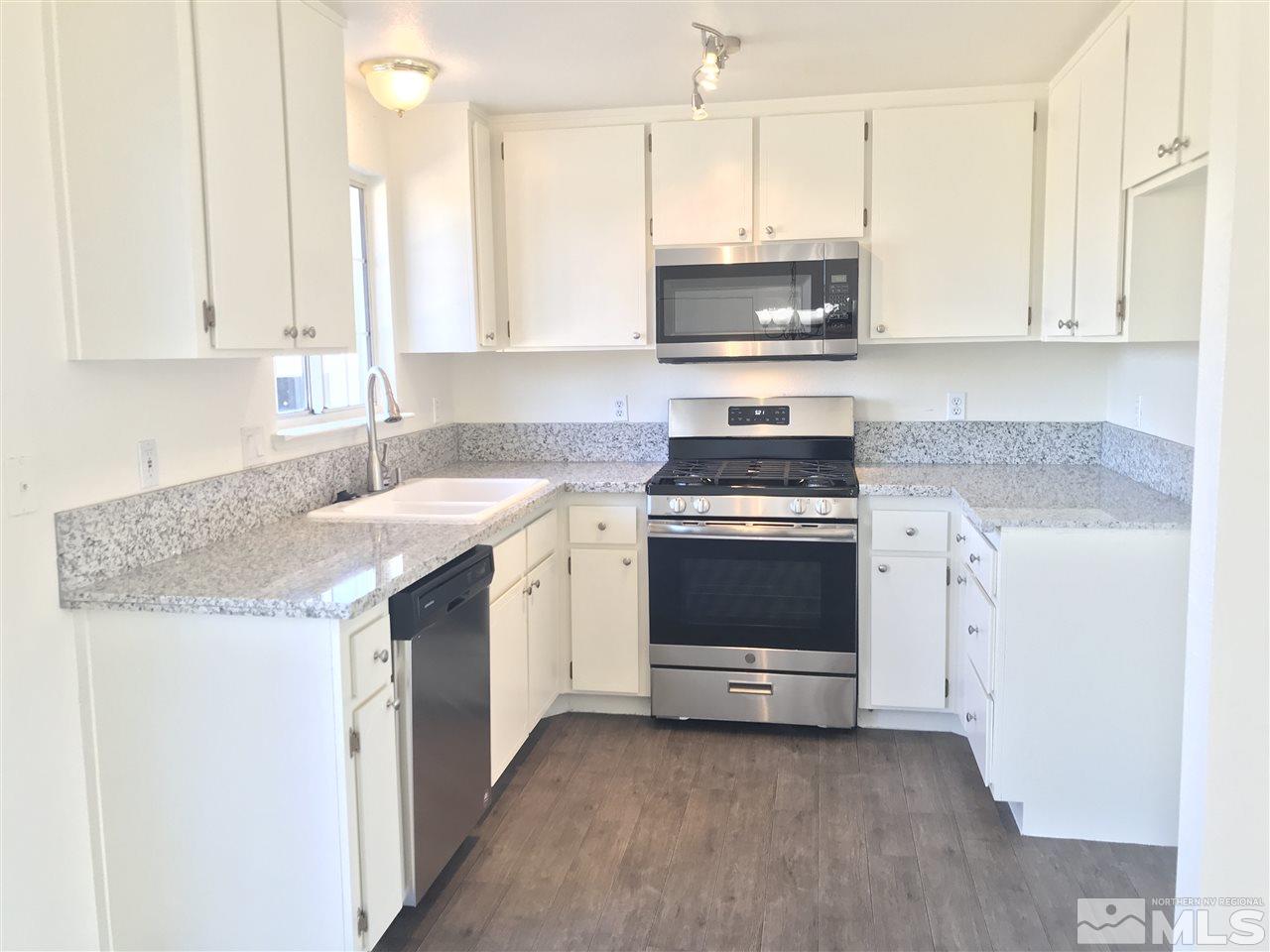 118 Empire Road Dayton, NV 89403 - Photo 5 of 16 a kitchen with stainless steel appliances granite countertop a stove a sink and a microwave