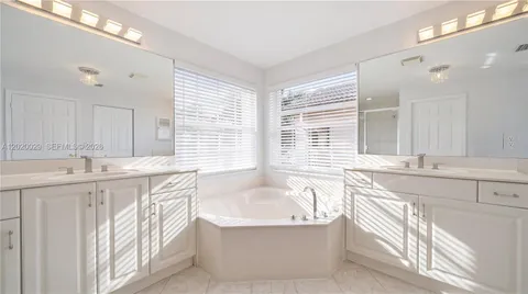 a bathroom with a granite countertop sink and a bathtub