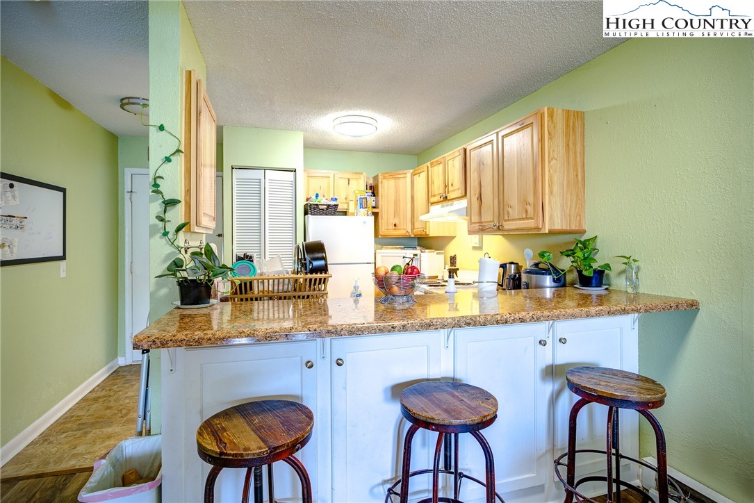 160 Zeb Street, Unit C104 Boone, NC 28607 - Photo 4 of 21 a kitchen with stainless steel appliances a table and chairs in it