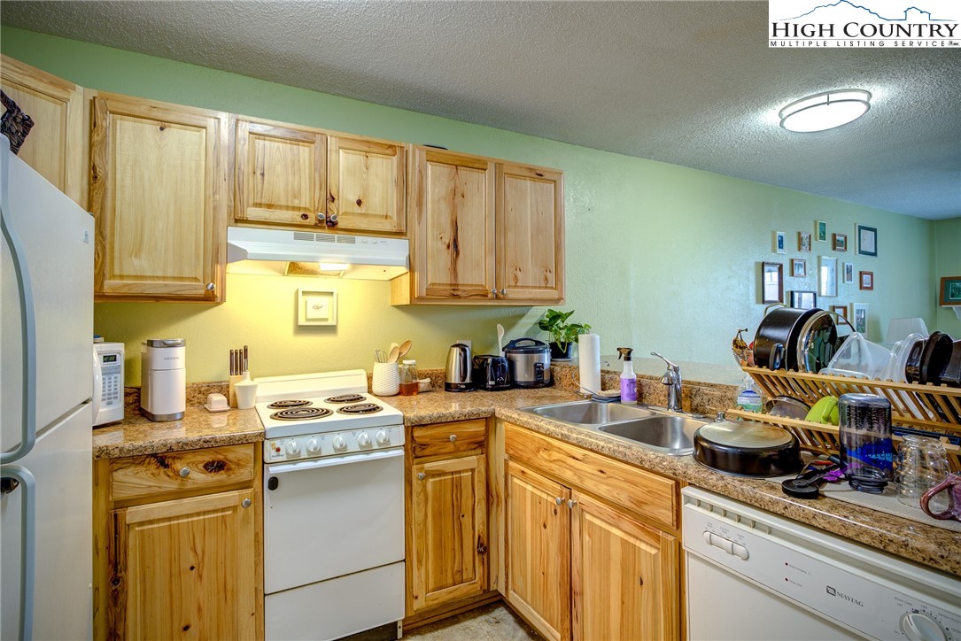 160 Zeb Street, Unit C104 Boone, NC 28607 - Photo 5 of 21 a kitchen with stainless steel appliances granite countertop a sink stove and cabinets