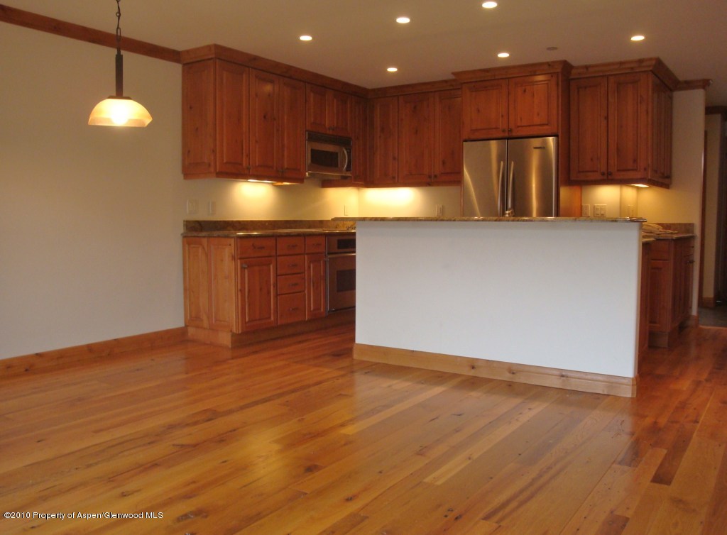 a kitchen with kitchen island granite countertop wooden cabinets and a granite counter tops