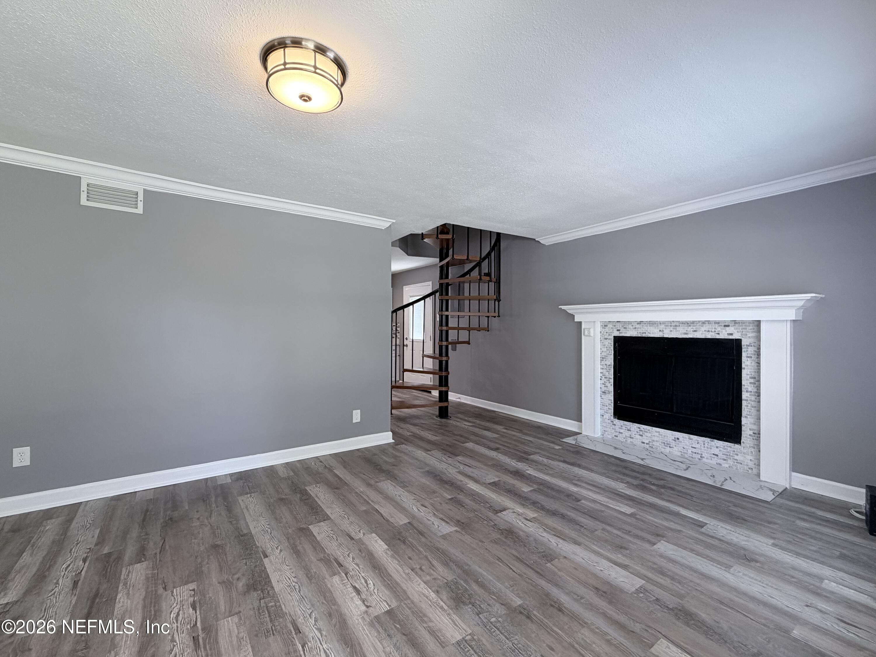 5336 Cruz Road Jacksonville, FL 32207 - Photo 4 of 29 a view of an empty room with wooden floor fireplace and a window