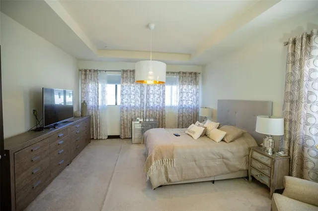 a bedroom with a bed and a flat tv screen on dresser