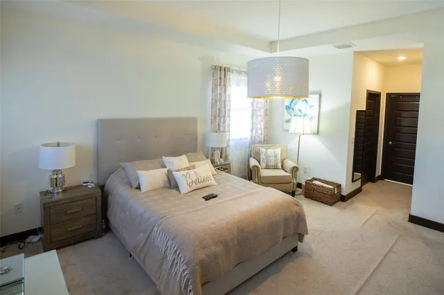 a bedroom with a bed a lamp and a large window