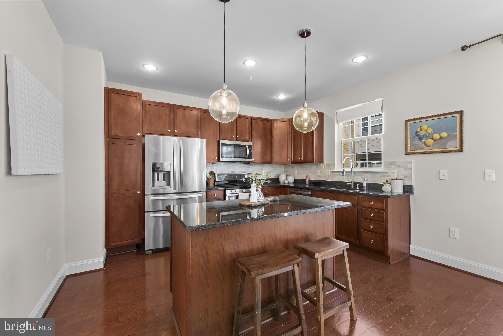 5948 Logans Way Ellicott City, MD 21043 - Photo 17 of 44 a kitchen with refrigerator a stove a sink and a chairs
