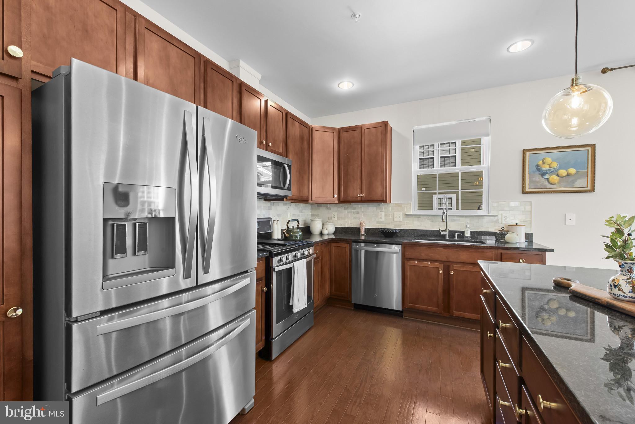 5948 Logans Way Ellicott City, MD 21043 - Photo 18 of 44 a kitchen with stainless steel appliances granite countertop a refrigerator sink and stove