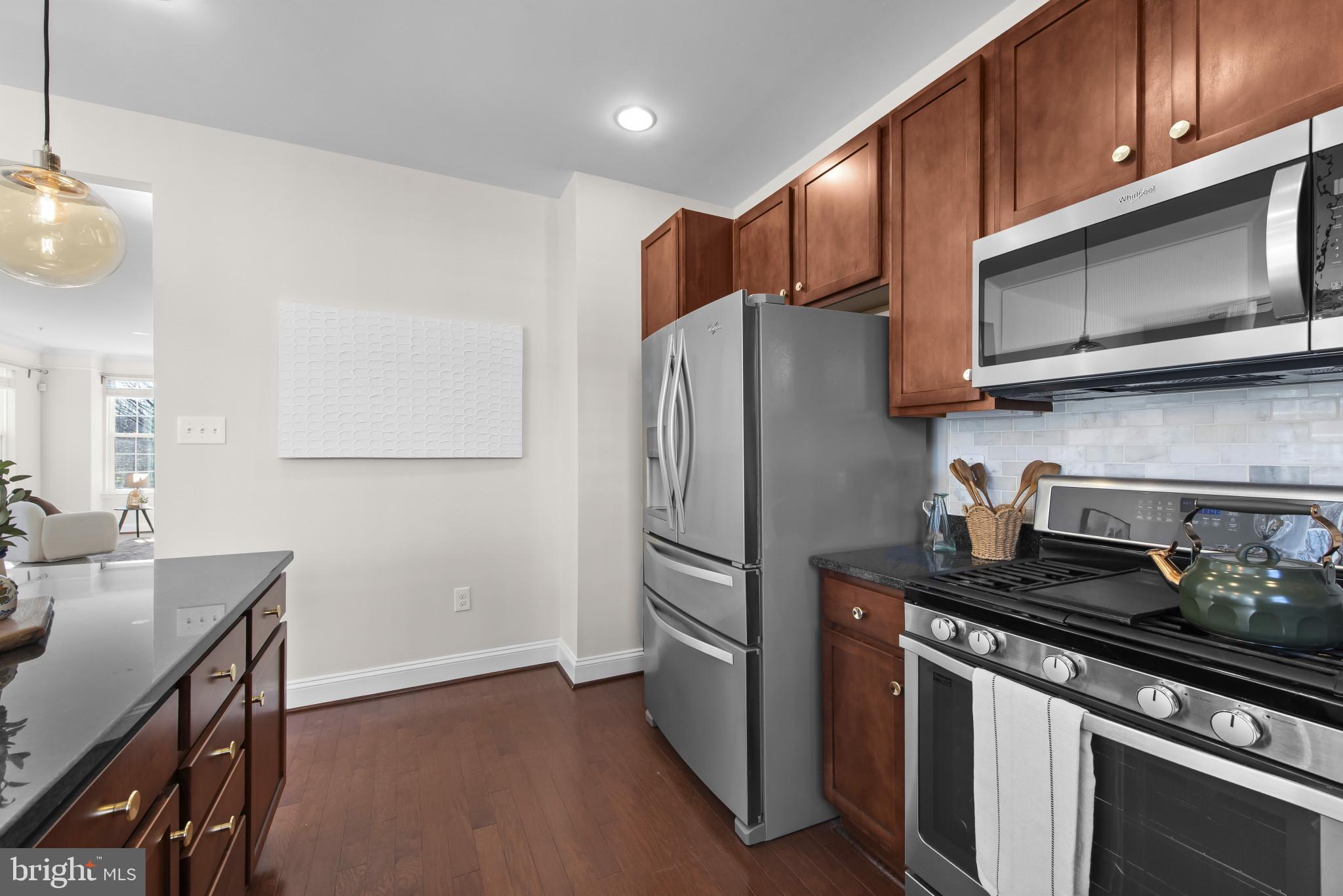 5948 Logans Way Ellicott City, MD 21043 - Photo 19 of 44 a kitchen with stainless steel appliances a stove a microwave a sink and cabinets