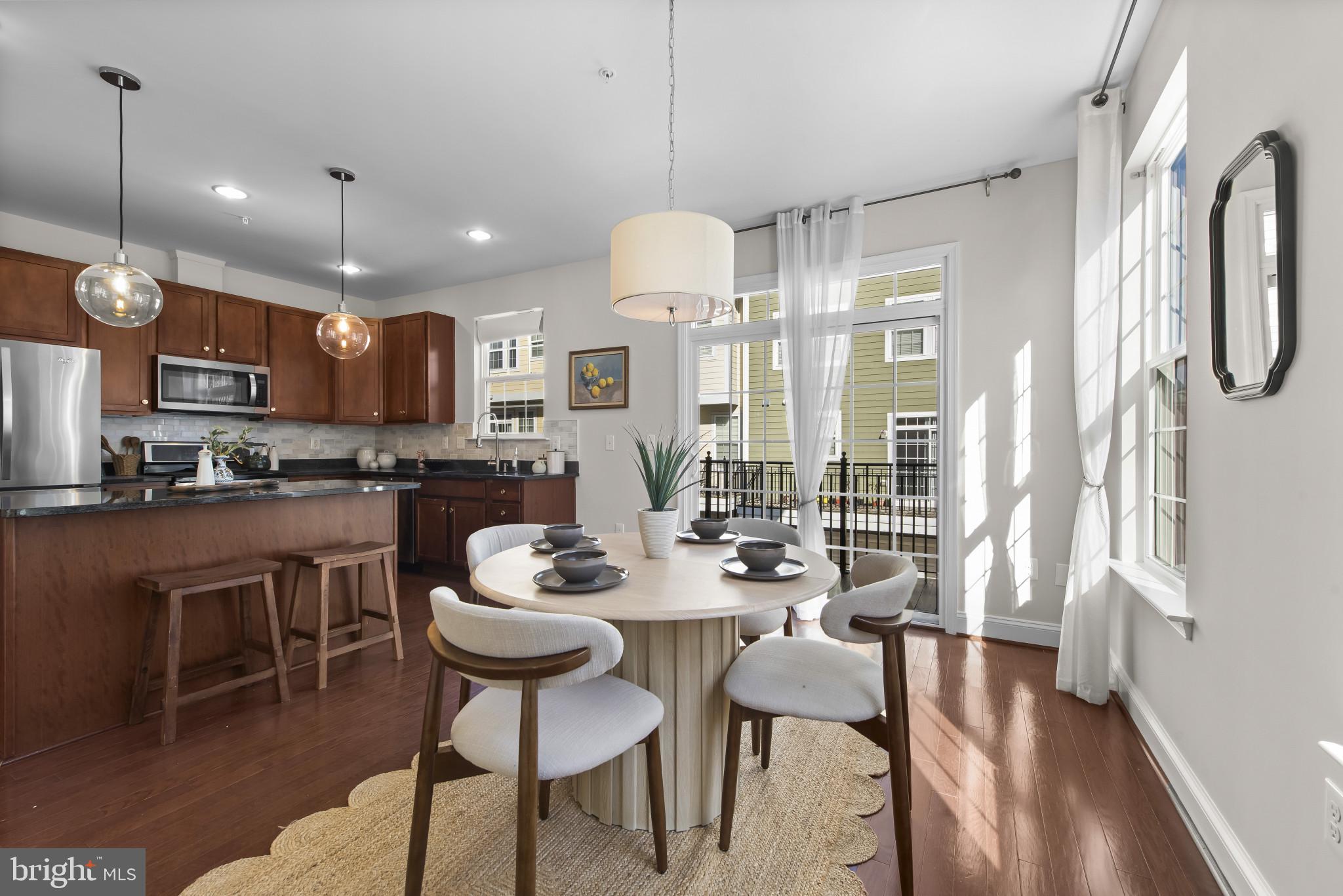 5948 Logans Way Ellicott City, MD 21043 - Photo 21 of 44 a kitchen with kitchen island a dining table and a refrigerator