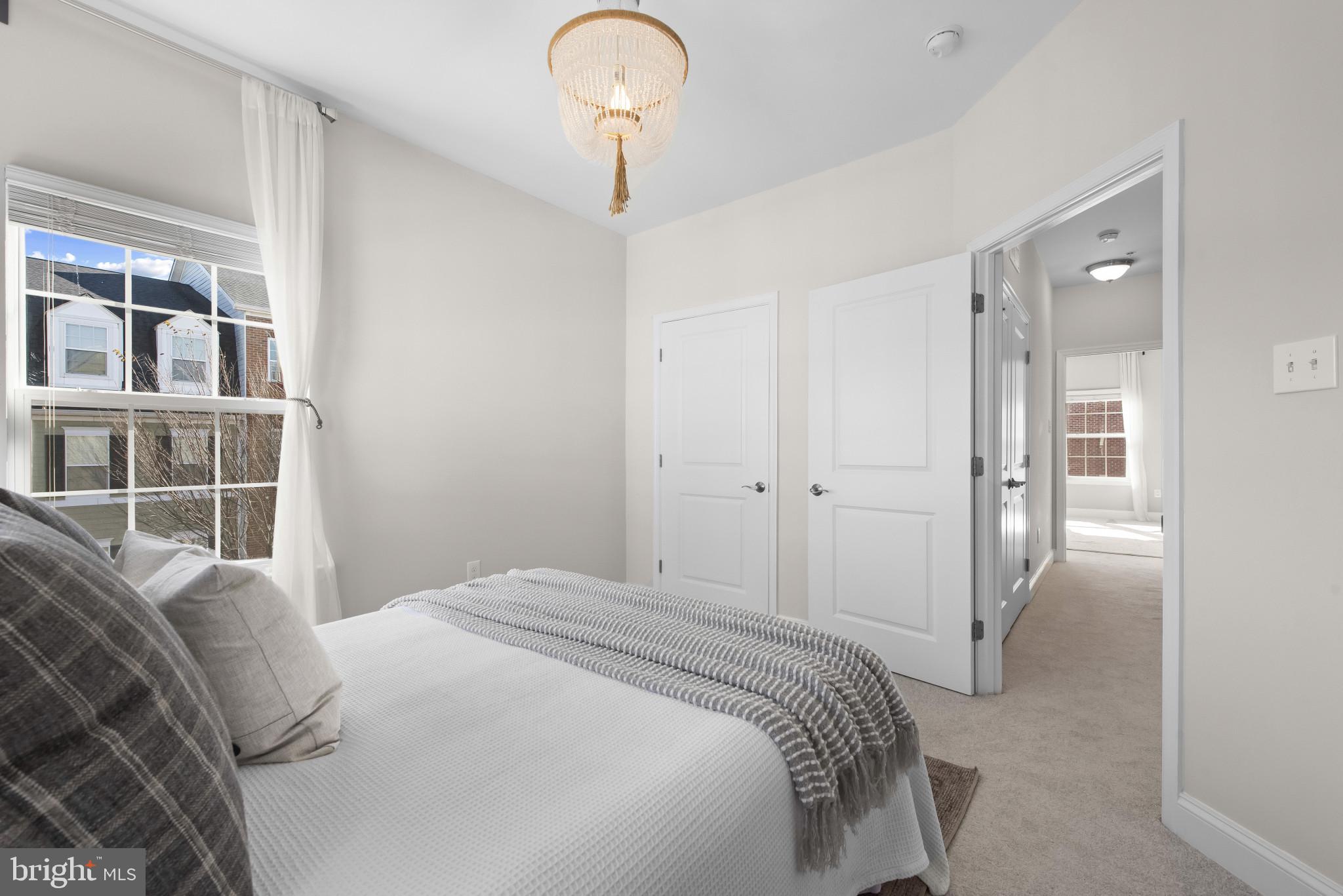 5948 Logans Way Ellicott City, MD 21043 - Photo 34 of 44 a bedroom with a large bed and a chandelier