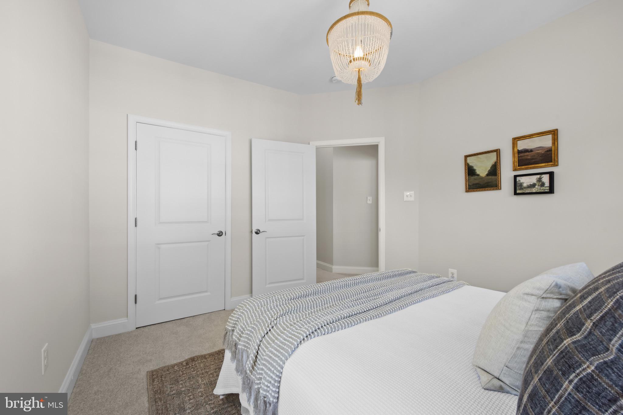 5948 Logans Way Ellicott City, MD 21043 - Photo 36 of 44 a bedroom with a bed and a chandelier