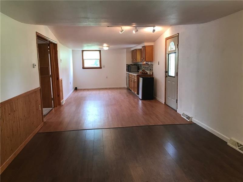 1102 Grant Street Bulger, PA 15019 - Photo 19 of 25 an empty room with wooden floor and kitchen view