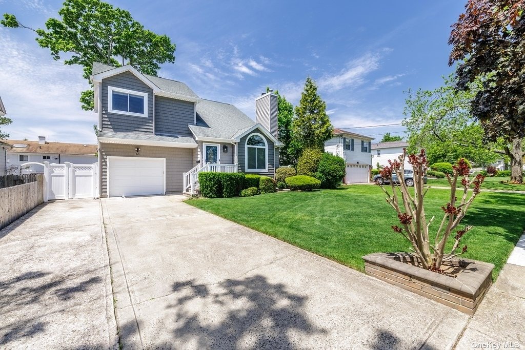 a front view of a house with a yard and potted plants