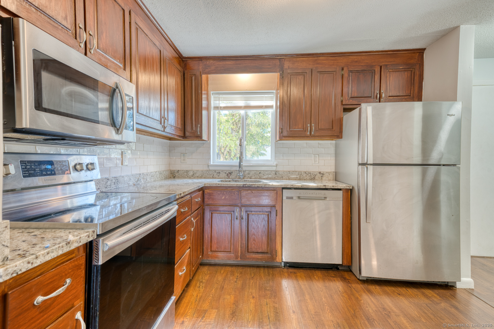 12 Stone Pond Road, Unit 12 Tolland, CT 06084 - Photo 8 of 31 a kitchen with granite countertop wooden cabinets stainless steel appliances and a window