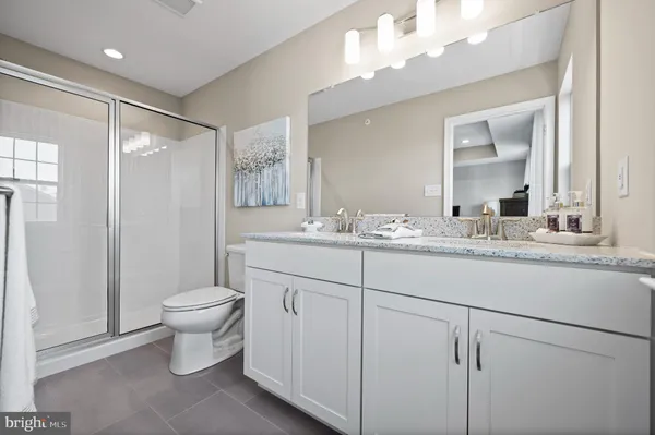 a bathroom with a toilet sink double vanity and mirror