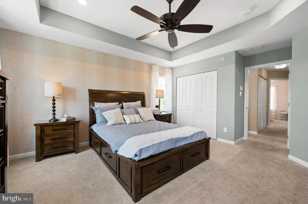 a spacious bedroom with a bed and a chandelier