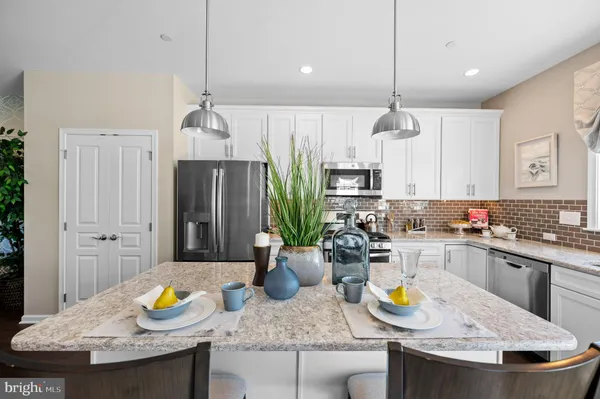 a kitchen with sink a refrigerator and chairs