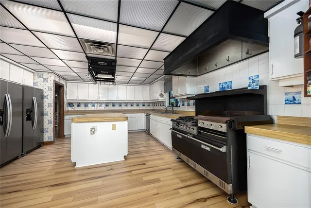 a kitchen with stainless steel appliances kitchen island granite countertop a stove and a refrigerator