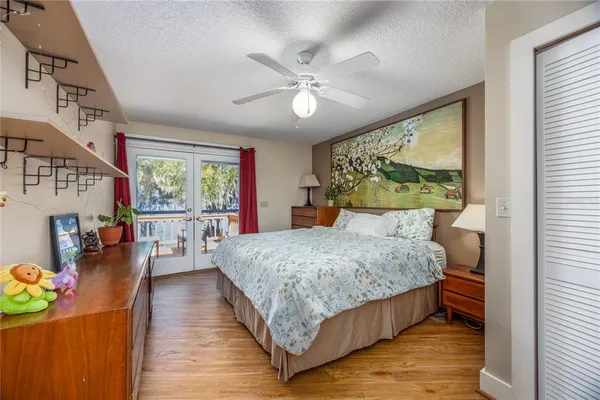 a bedroom with a bed a large window closet and flat screen tv